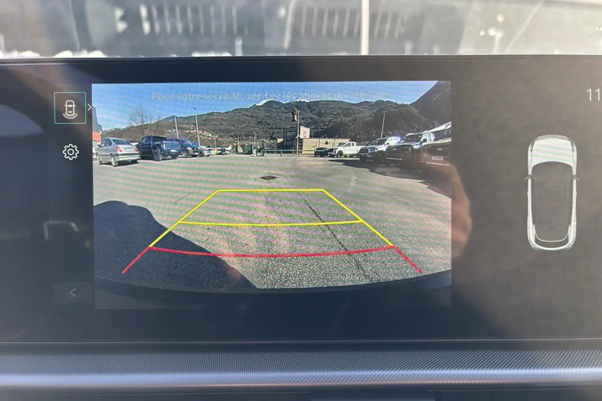 Vue écran caméra de recul du Kia Sportage gris eclipse 2026, avec lignes d’aide au stationnement colorées.