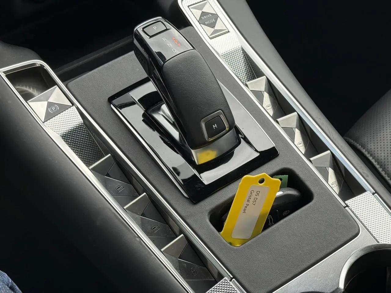 Gros plan sur la console centrale du DS7 2025 avec levier de boîte auto et clé avec étiquette Cristal Pearl.