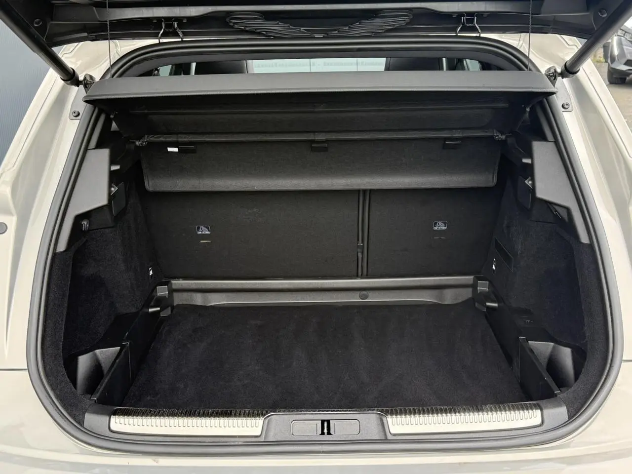 Coffre ouvert vu de l'arrière du DS7 Cristal Pearl 2025, intérieur noir avec hayon électrique et cache-bagages.