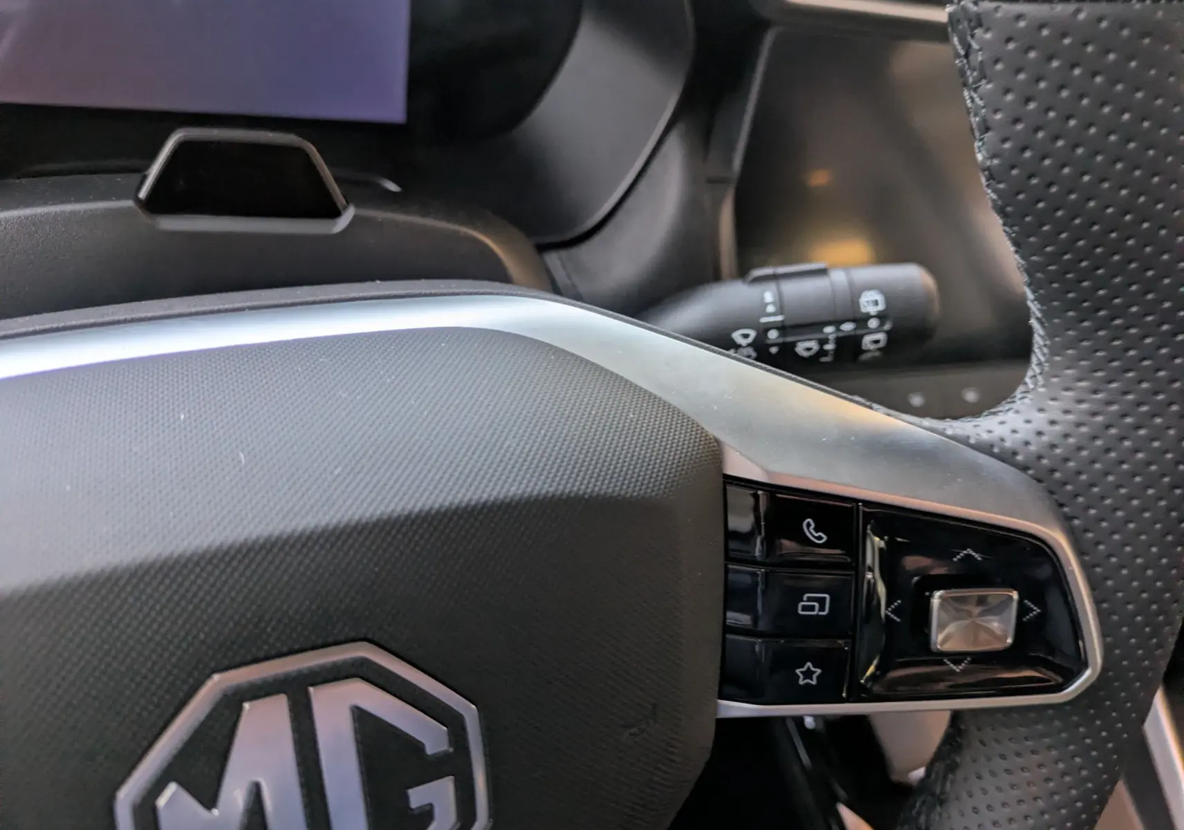 Gros plan sur le volant noir perforé de la MG ZS 2026 avec commandes intégrées côté droit.