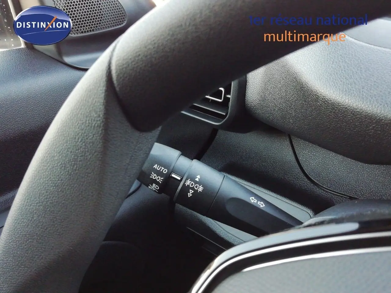Gros plan sur la manette de clignotants côté gauche du Peugeot Partner blanc Kaolin, intérieur noir texturé.