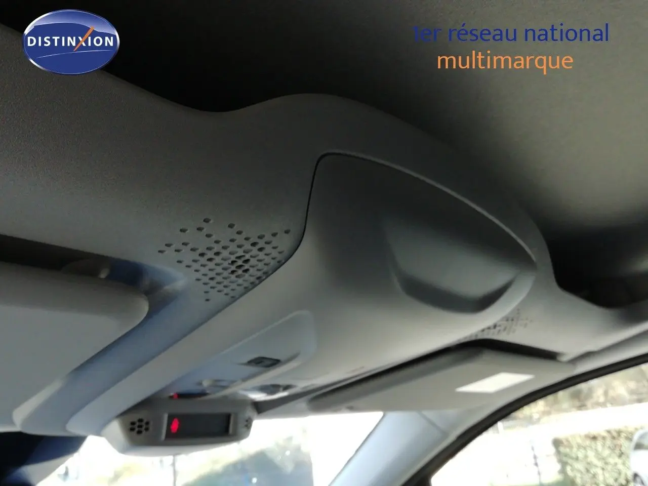 Vue intérieure du plafond avant du Peugeot Partner blanc Kaolin 2026, montrant la console de toit avec éclairage et commandes.