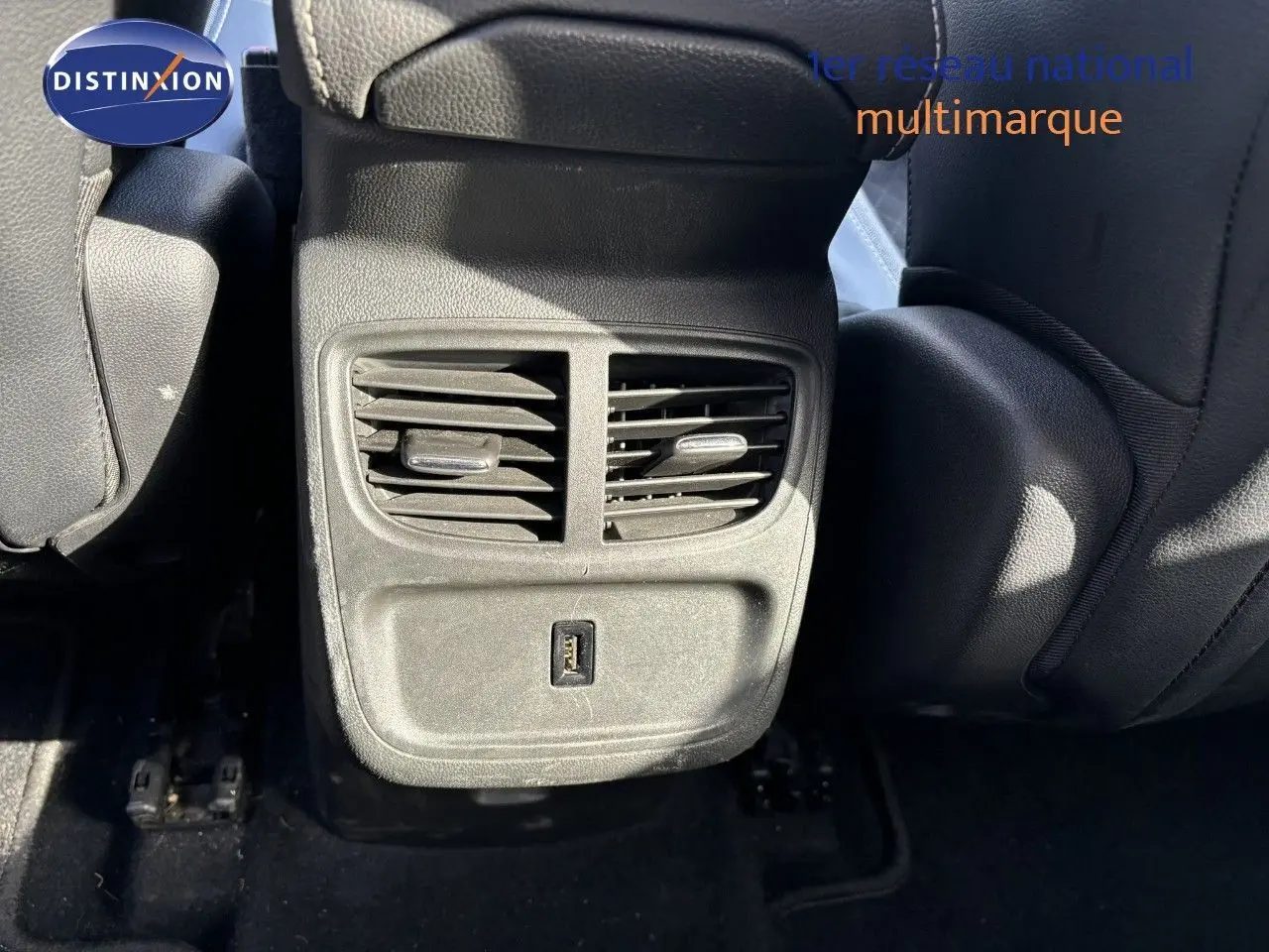 Vue rapprochée des aérateurs arrière et port USB entre les sièges noirs d'un Opel Grandland X 2019.