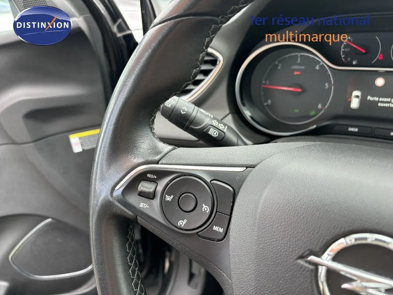 Gros plan sur le volant en cuir noir de l'Opel Grandland X 2019, avec commandes intégrées et tableau de bord visible.