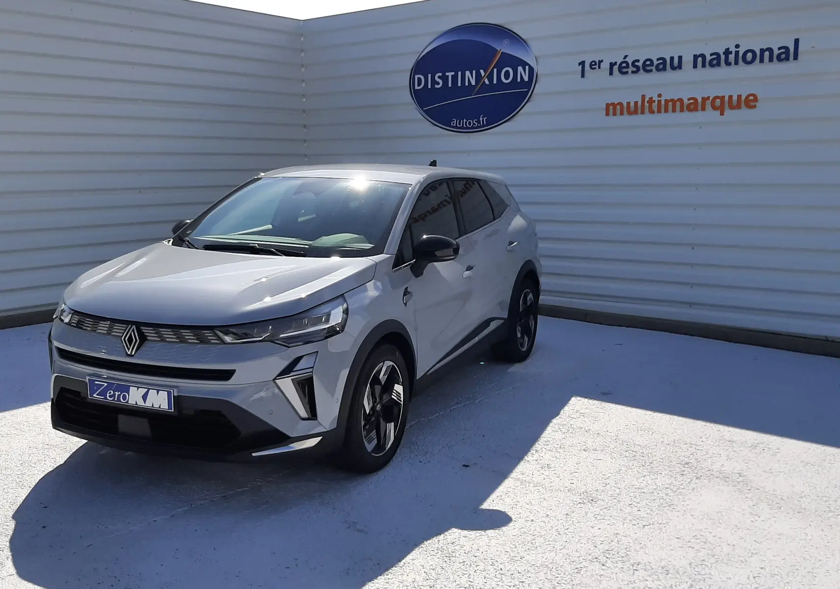 Renault Symbioz gris Rafale en 3/4 avant droit, avec calandre moderne et jantes bicolores distinctives.