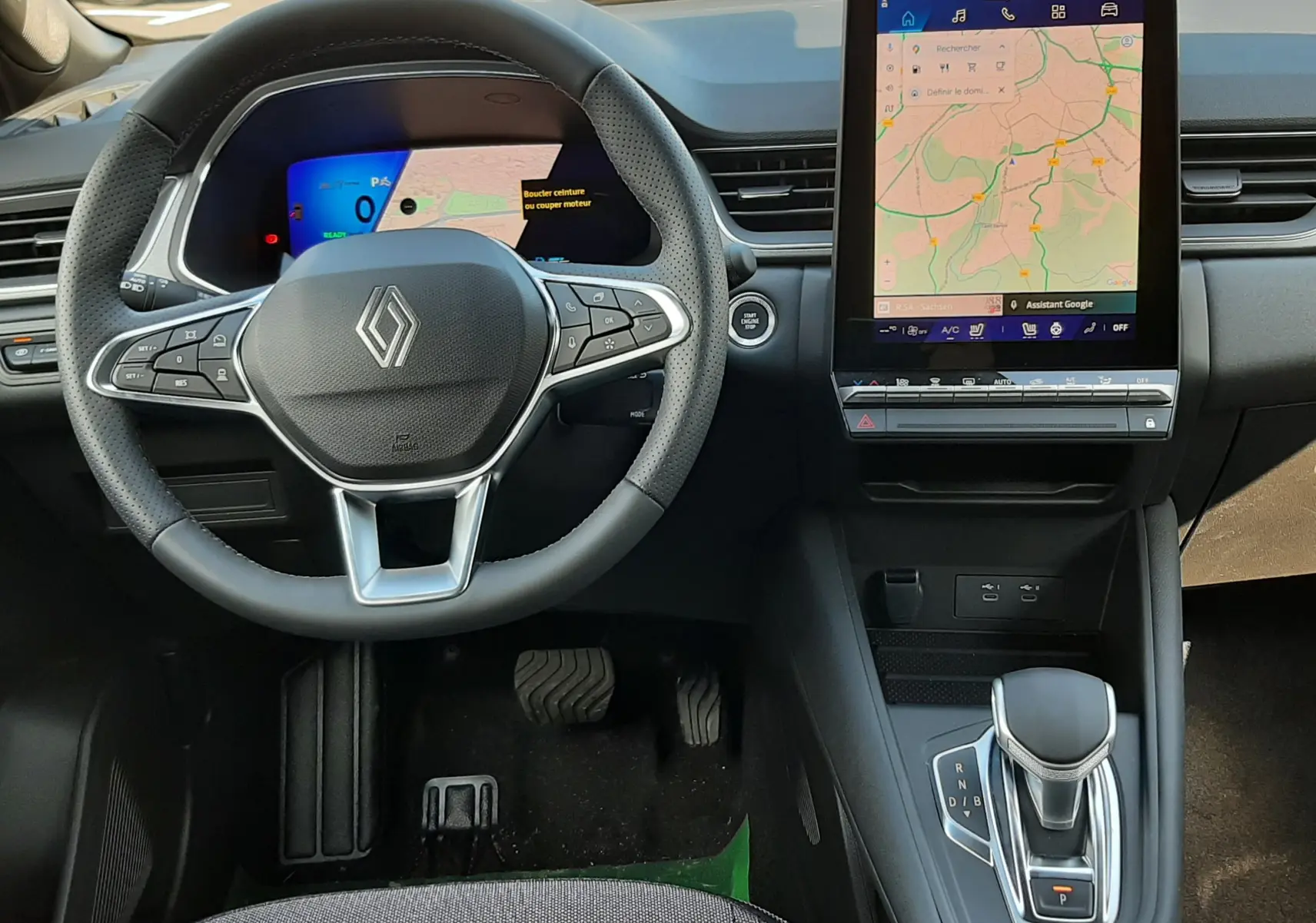 Vue intérieure du tableau de bord et volant Renault SYMBIOZ gris rafale, avec écran tactile central affichant une carte GPS.