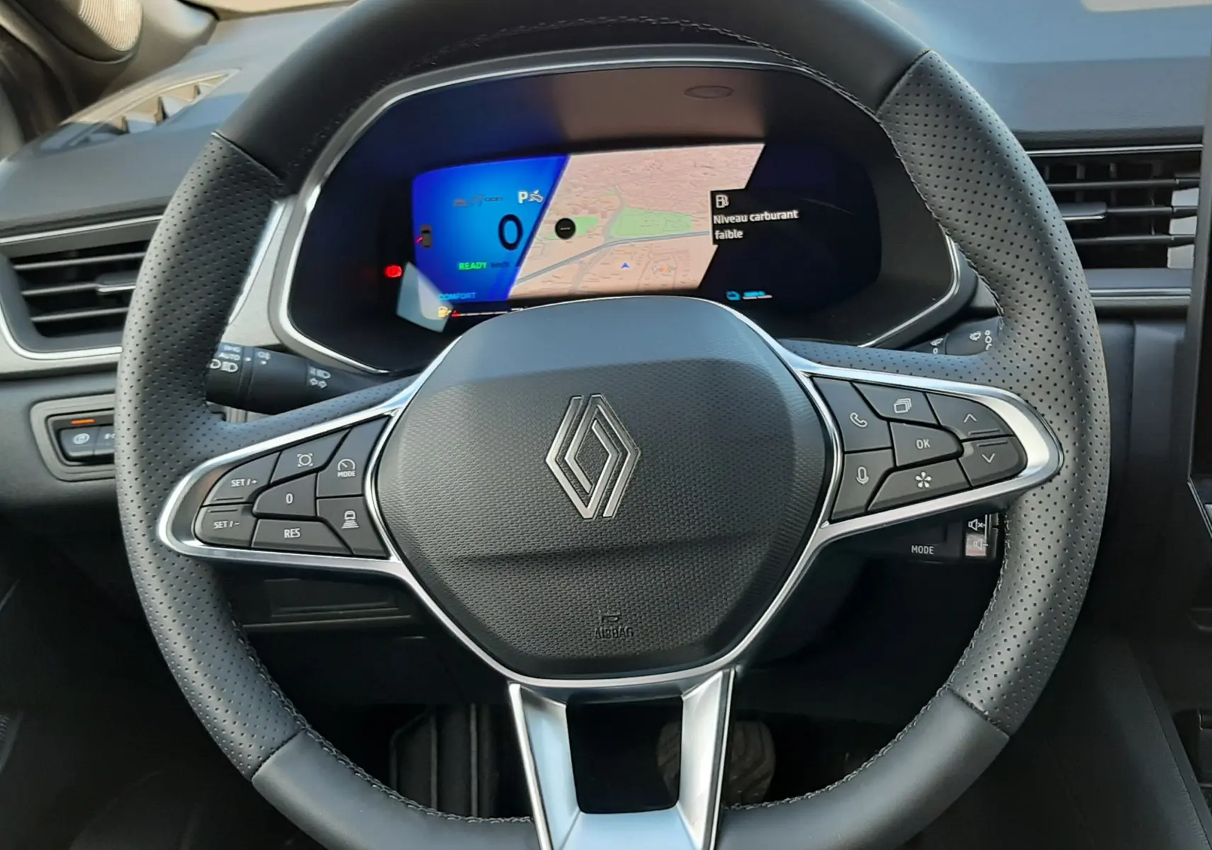 Vue intérieure centrée sur le volant en cuir perforé noir de la Renault Symbioz 2024 avec tableau de bord numérique affichant la navigation.