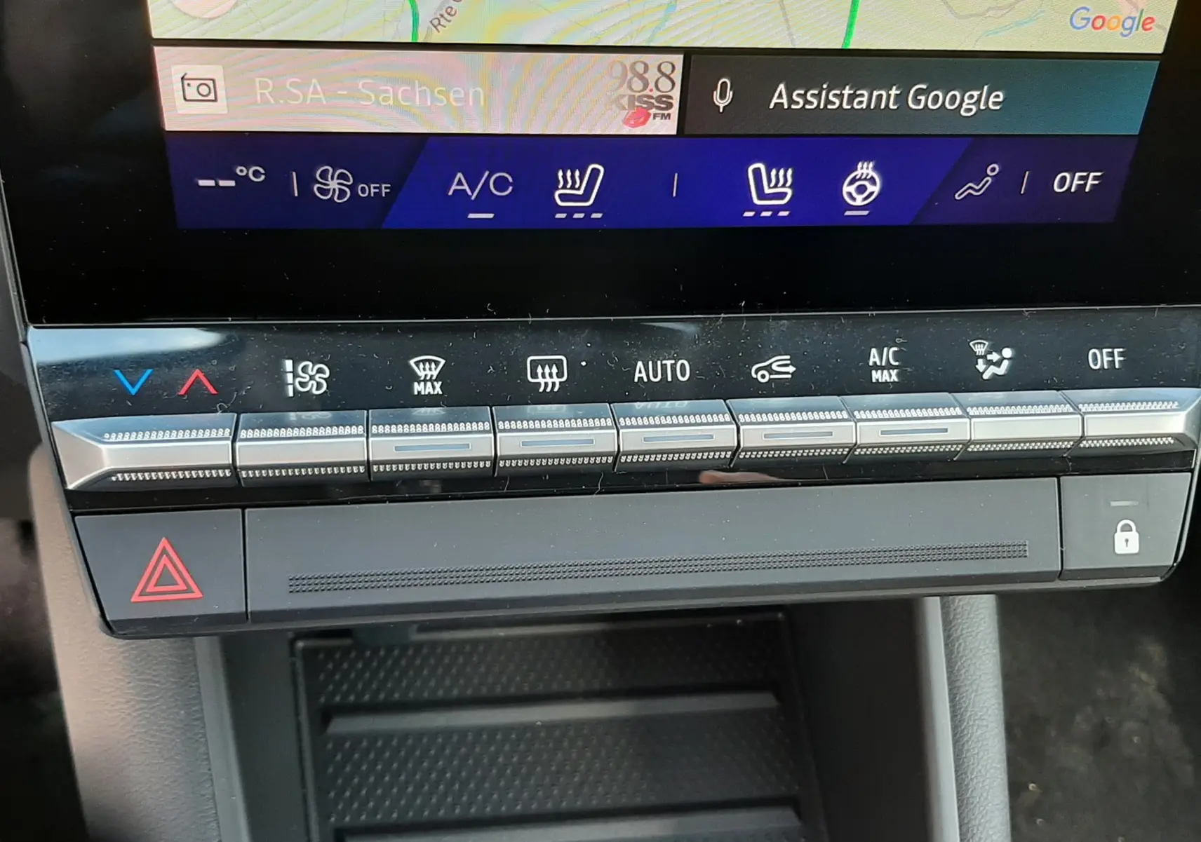 Gros plan sur la console centrale du Renault Symbioz 2024, montrant les commandes tactiles de climatisation et le bouton de warning.