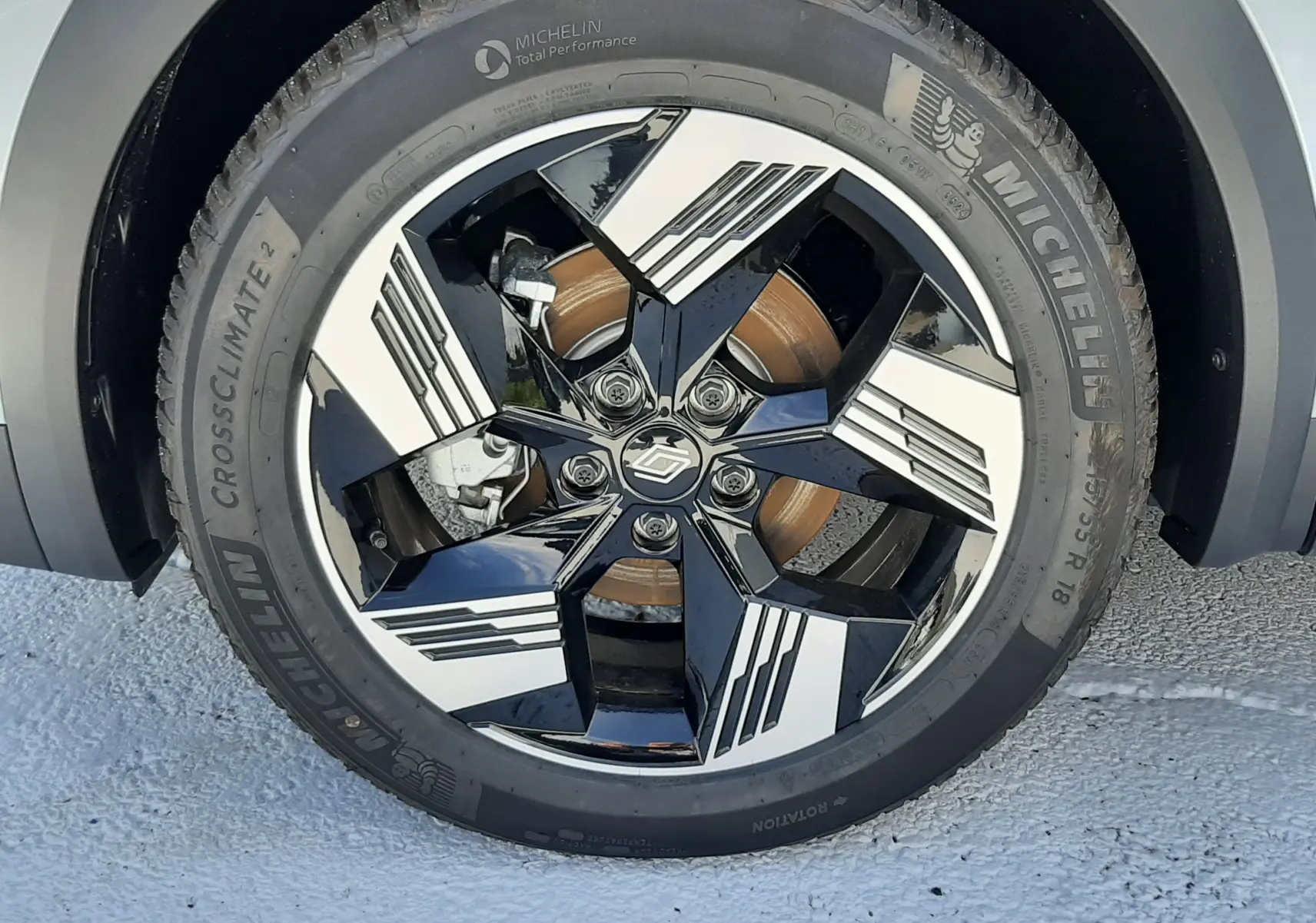 Gros plan sur la roue avant droite du Renault Symbioz gris Rafale, jante noire et blanche au design géométrique.