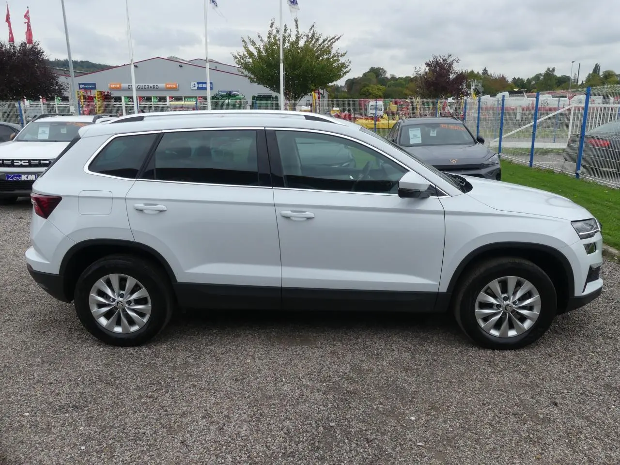 Profil latéral droit d'un SUV SKODA KAROQ blanc avec jantes alliage 17'' et vitres surteintées.