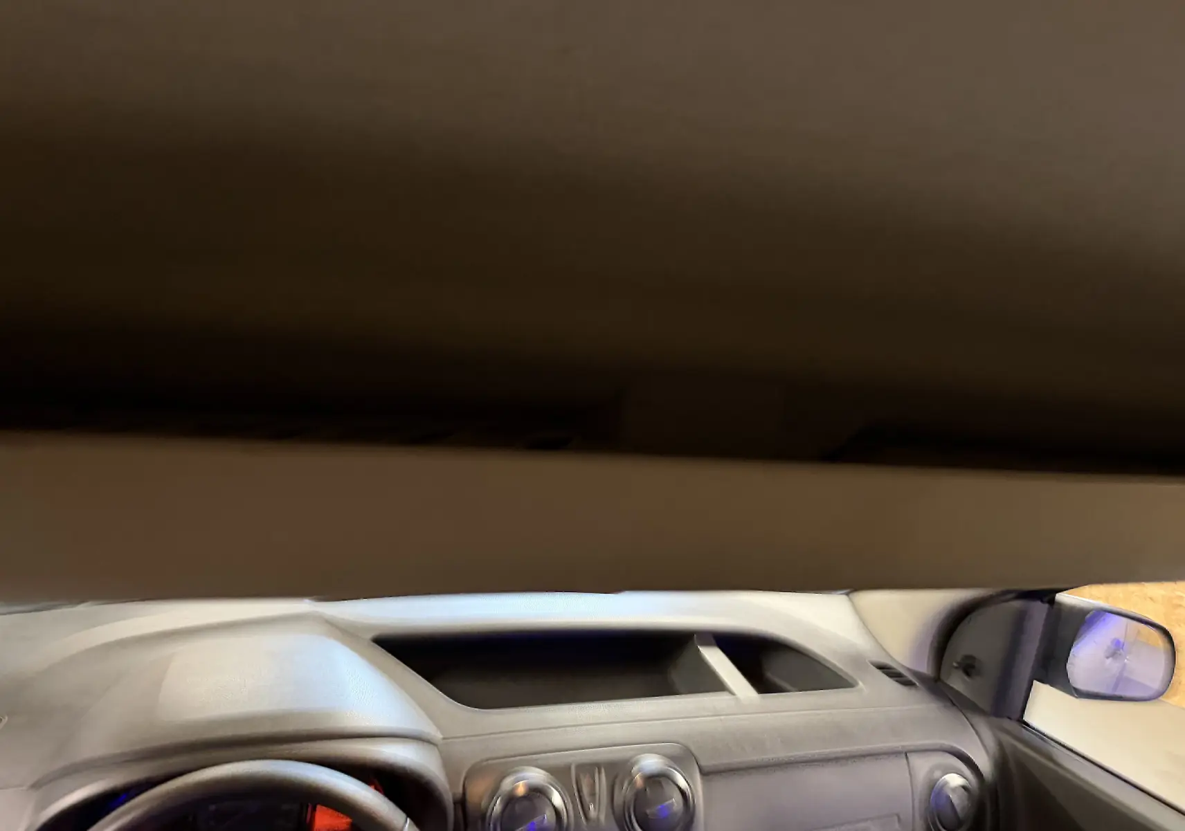 Vue intérieure du tableau de bord gris du Dacia Dokker 2019 avec volant multifonctions et commandes centrales visibles.