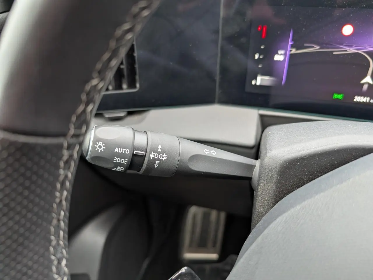 Gros plan sur la commande des feux et clignotants à gauche du volant dans l’Opel Astra gris métallisé 2024.