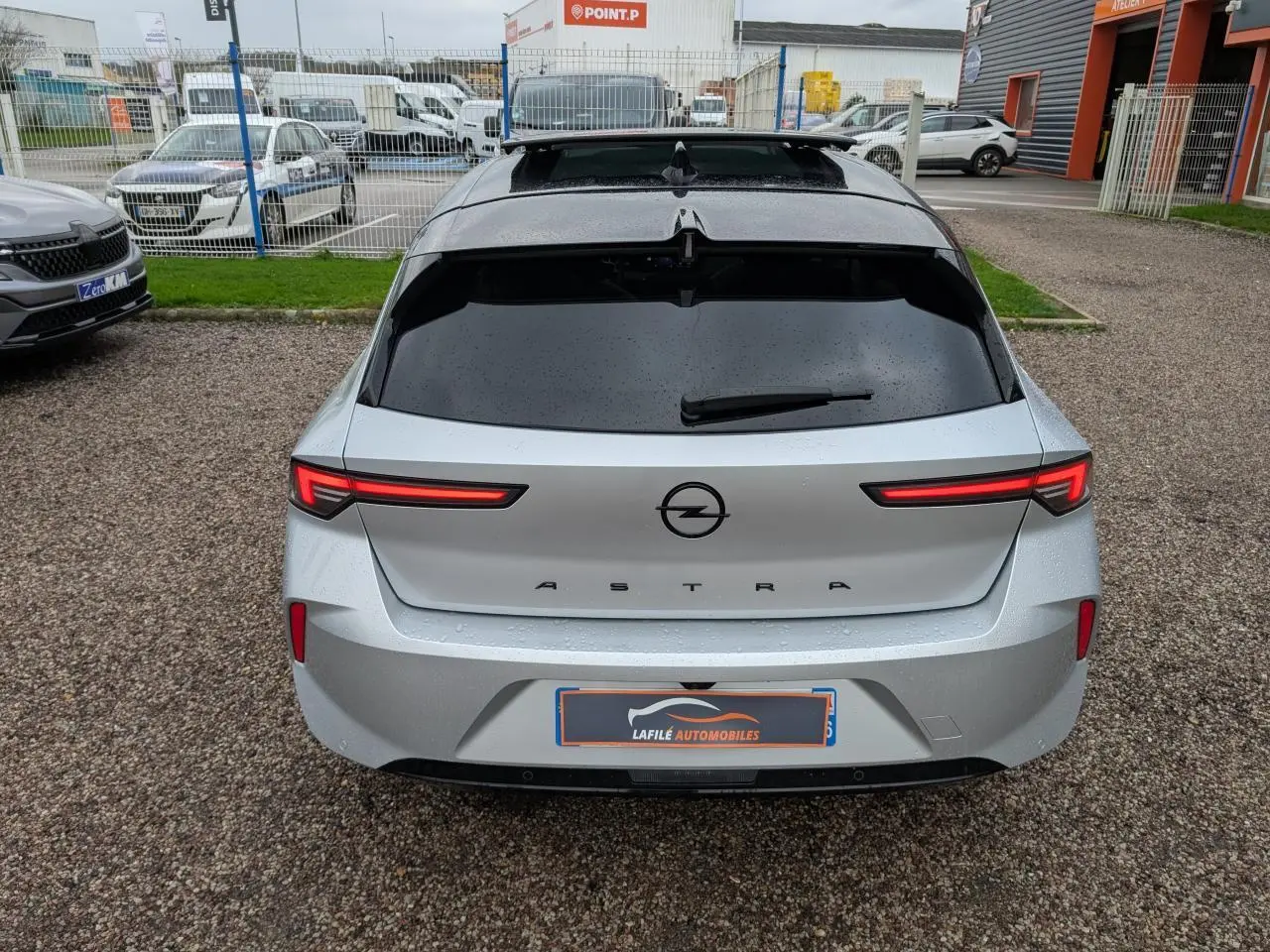 Vue arrière d'une Opel Astra 2024 gris métallisé avec feux arrière LED fins et lunette arrière teintée.