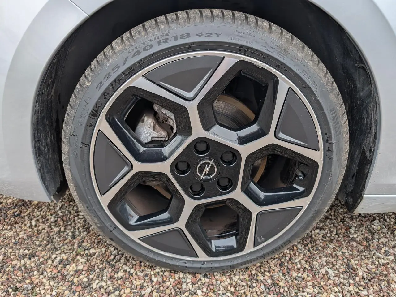 Gros plan sur la roue avant droite d'une Opel Astra 2024 gris métallisé avec jante alliage noire et argent.