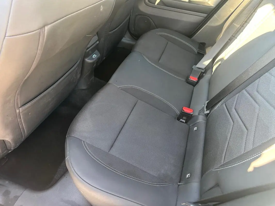 Vue intérieure côté droit des sièges arrière noirs du Jeep Avenger 2025 avec surpiqûres blanches et ceintures de sécurité.