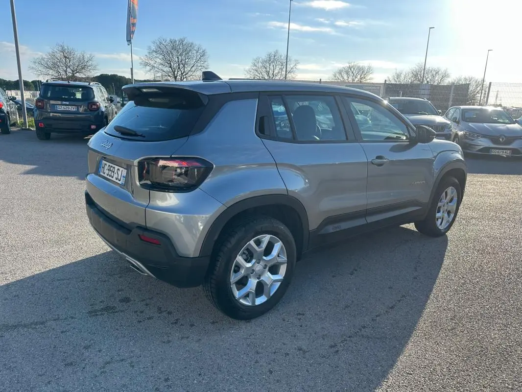 Jeep Avenger gris foncé vu en 3/4 arrière droit, avec jantes alliage 17 pouces et toit noir contrasté.