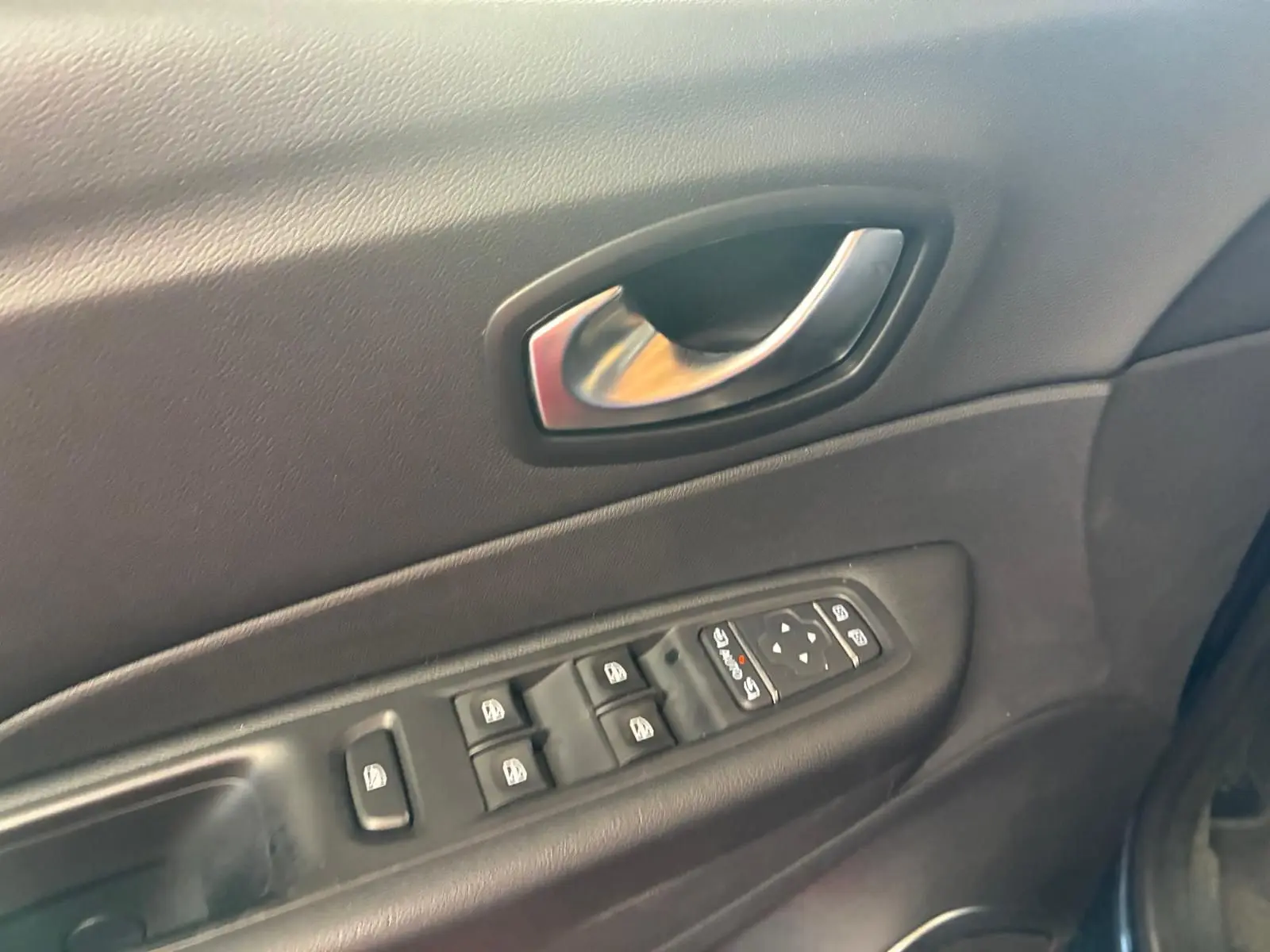 Gros plan sur la porte intérieure côté conducteur du Renault Captur 2017, avec commandes électriques des vitres et poignée argentée.