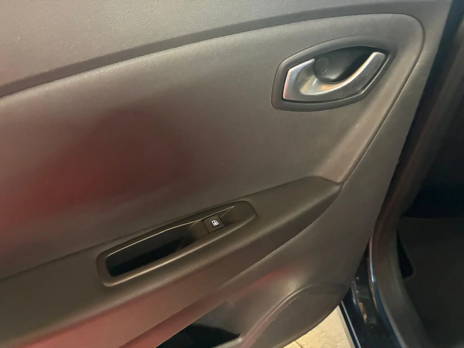 Gros plan sur la porte intérieure côté conducteur du Renault Captur bleu 2017, avec poignée et bouton de vitre électrique.