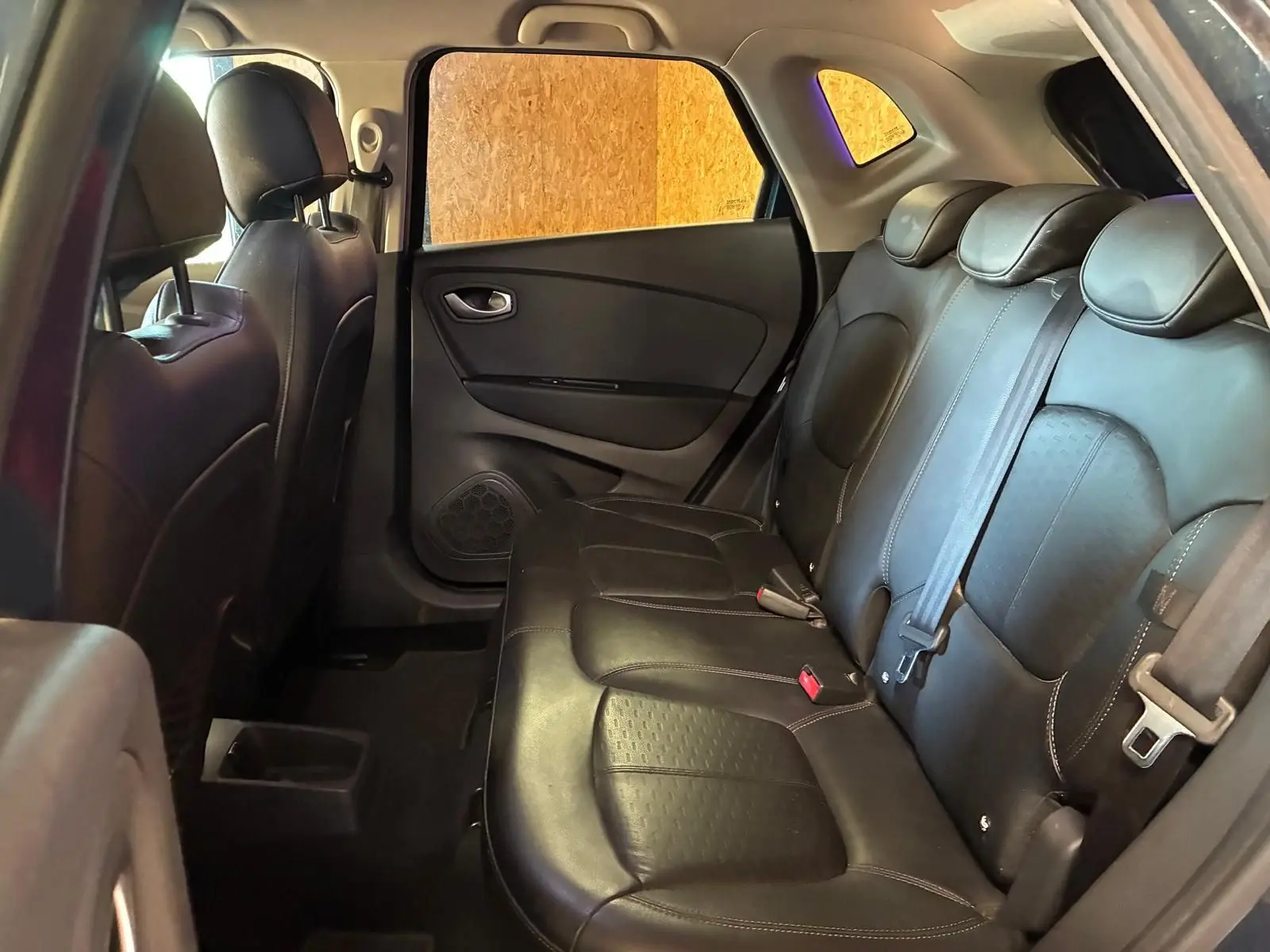 Vue intérieure côté droit montrant la banquette arrière en cuir noir du Renault Captur 1.5 DCI 90 Intens 2017.