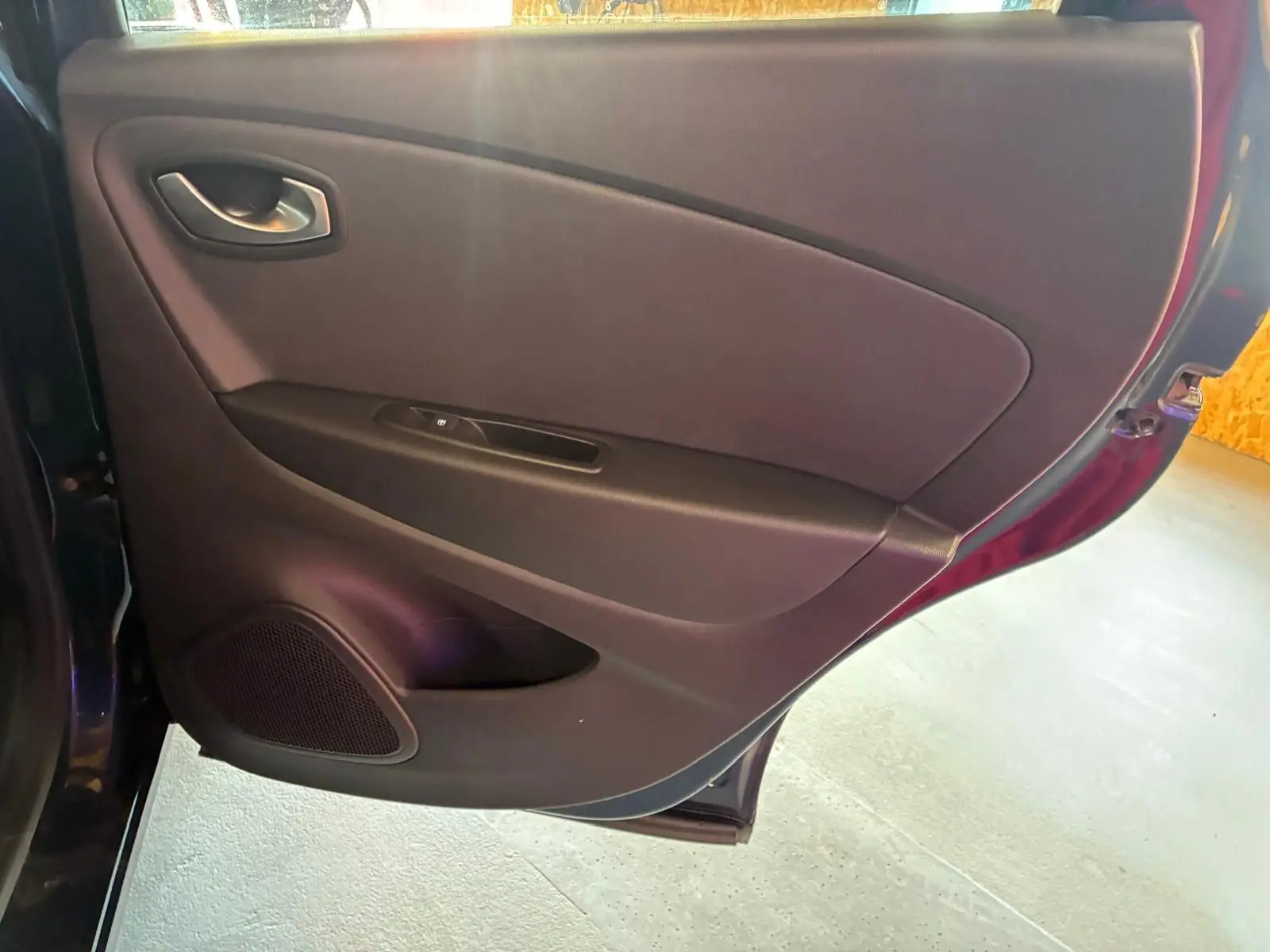 Vue intérieure de la porte arrière gauche du Renault Captur bleu 2017, avec panneau noir et haut-parleur intégré.