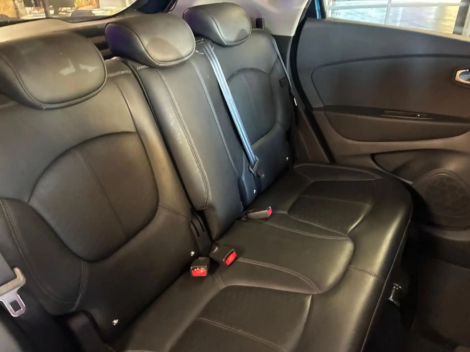 Vue intérieure des sièges arrière en cuir noir du Renault Captur 1.5 DCI 90 Intens, avec ceinture de sécurité visible.