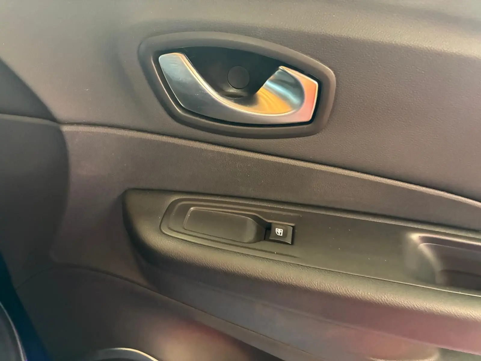 Poignée intérieure de porte côté gauche en plastique noir avec bouton de commande de vitre sur Renault Captur bleu 2017.