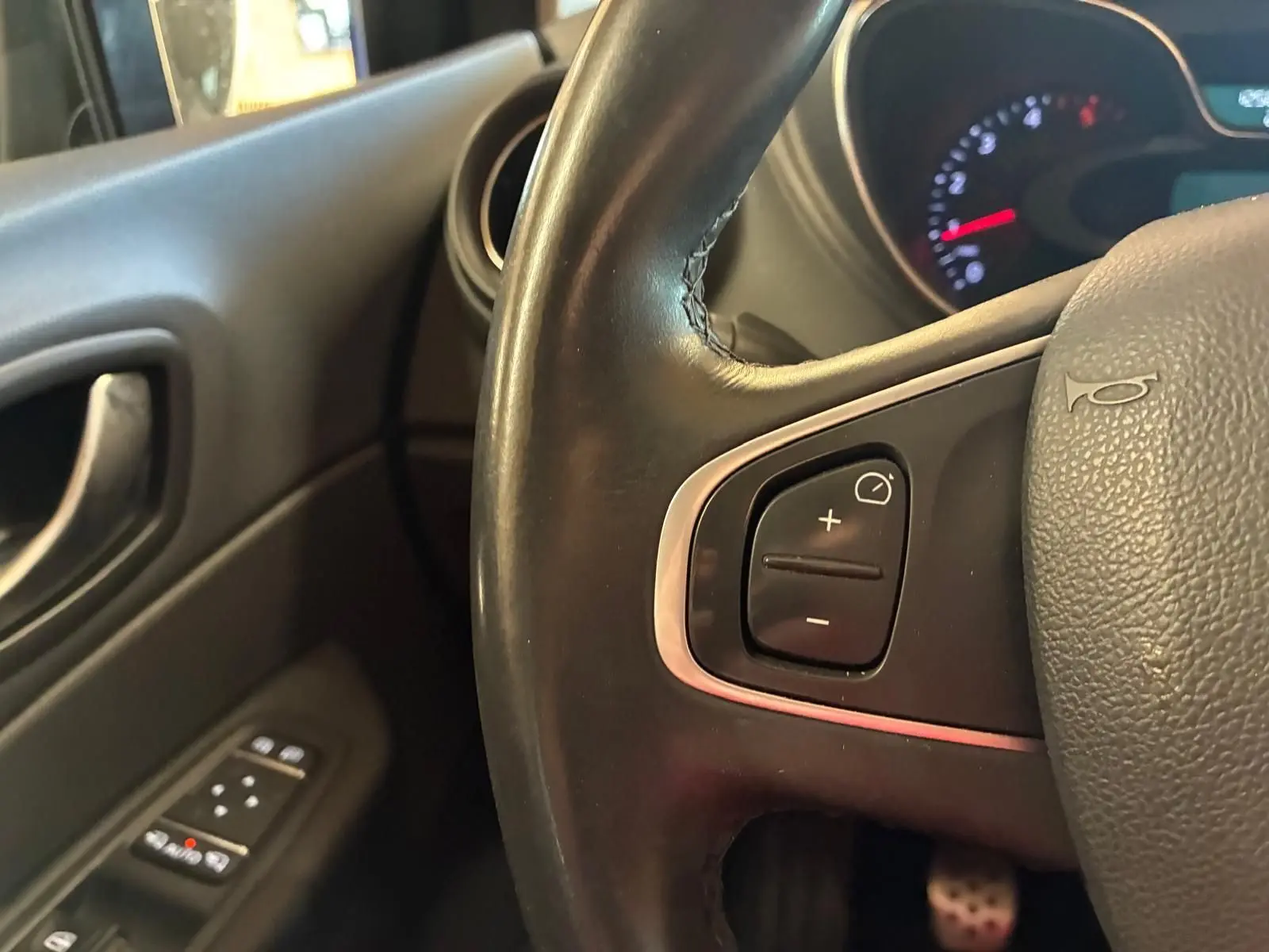 Gros plan sur le volant noir côté gauche du Renault Captur 1.5 DCI 90 Intens avec commandes intégrées et tableau de bord partiellement visible.