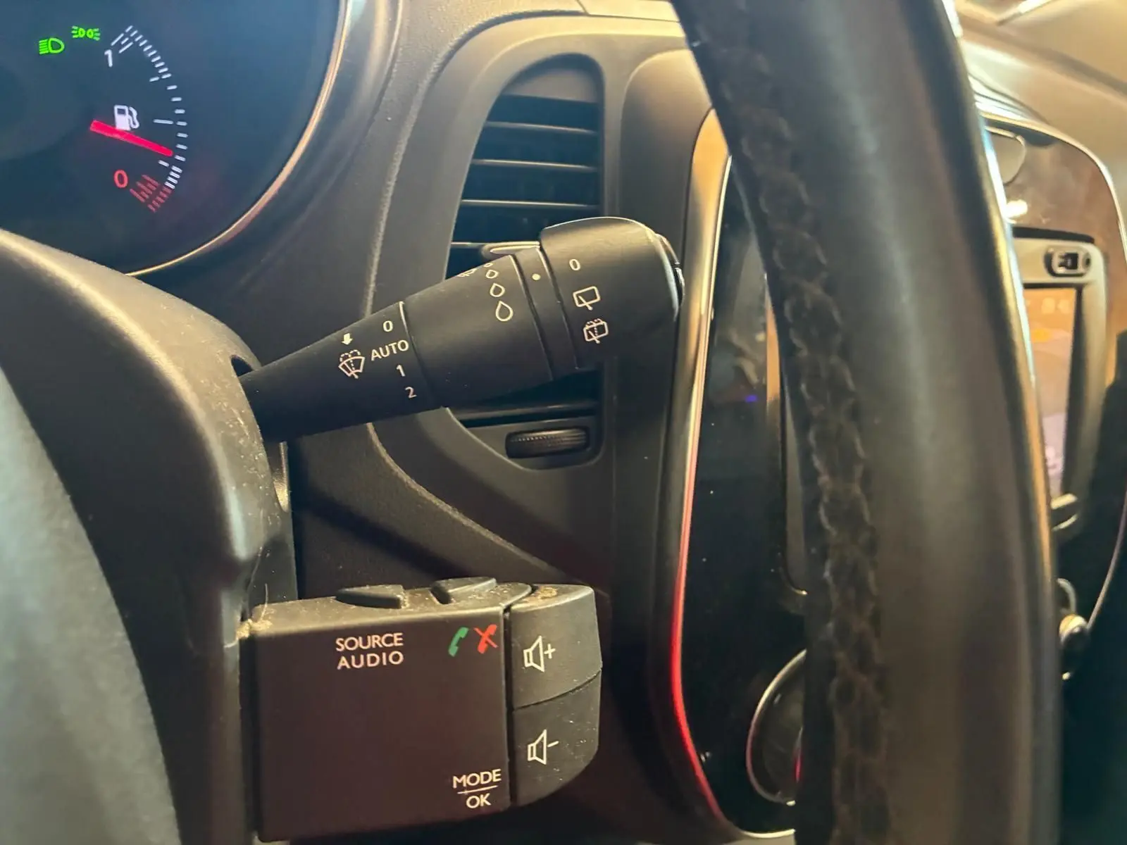 Gros plan sur la commande d’essuie-glace et les boutons audio derrière le volant du Renault Captur bleu 2017.