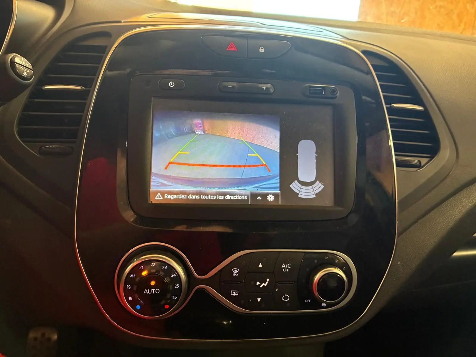 Vue rapprochée de l’écran central du Renault Captur 2017 montrant la caméra de recul et les commandes de climatisation.