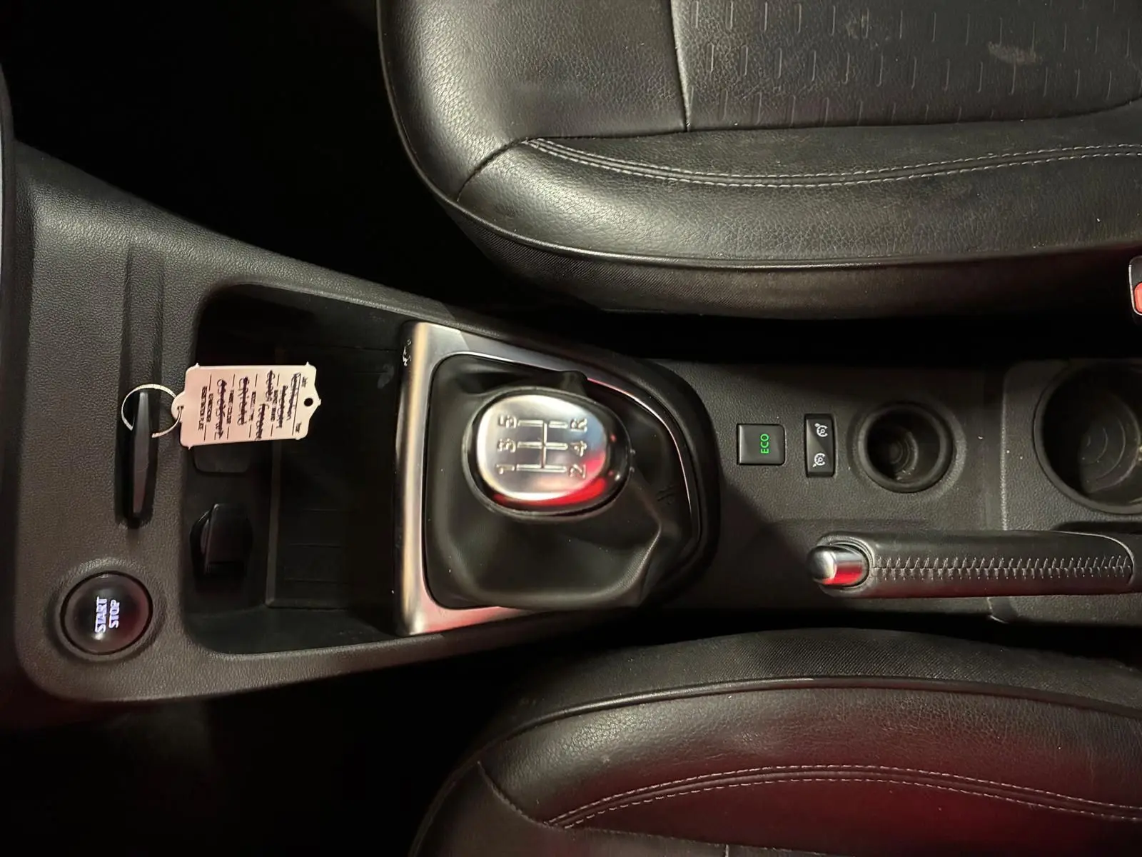 Vue rapprochée de la console centrale du Renault Captur bleu 2017, montrant levier de vitesse manuel et frein à main en cuir noir.