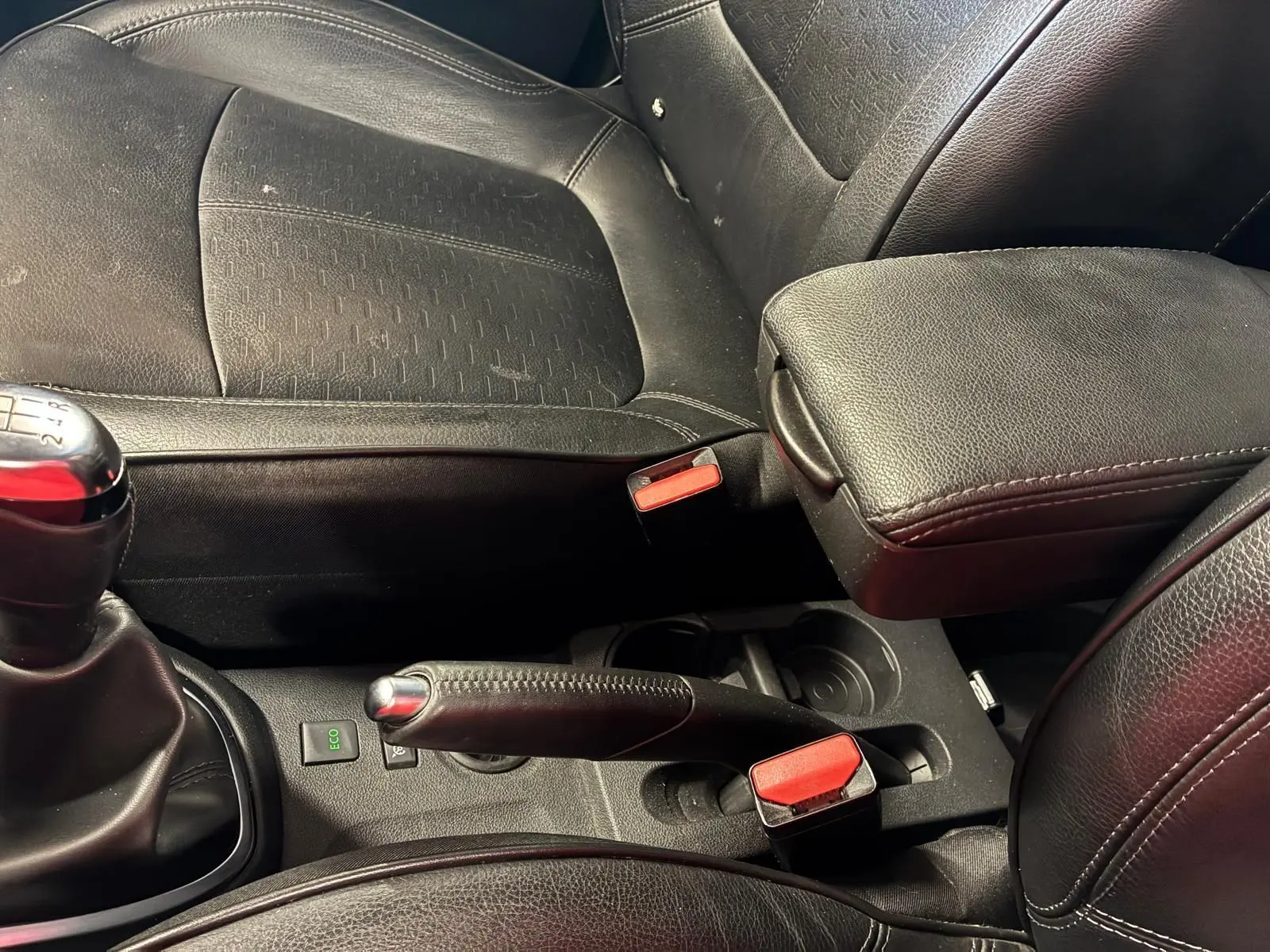 Gros plan intérieur sur la console centrale noire du Renault Captur bleu, montrant levier de vitesse manuel et frein à main.