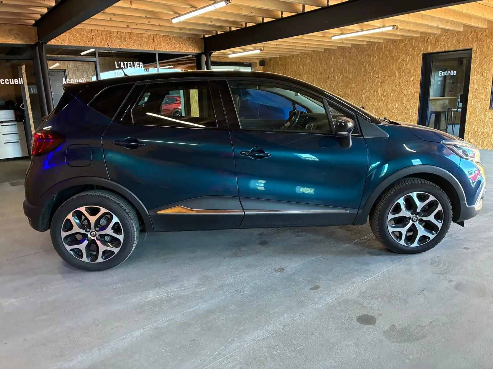 Renault Captur 1.5 DCI 90 Intens bleu en profil droit, avec jantes alliage et détails noirs contrastants.