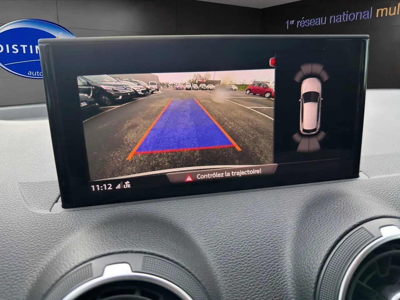 Écran central montrant la caméra de recul et l'aide au stationnement du tableau de bord d'un Audi Q2 noir Mito.
