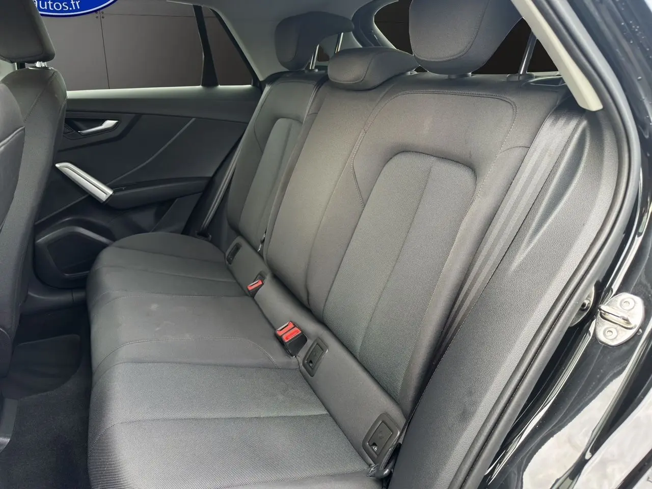 Vue intérieure côté droit des sièges arrière en tissu noir du SUV Audi Q2 35 TFSI S-Line 2023.