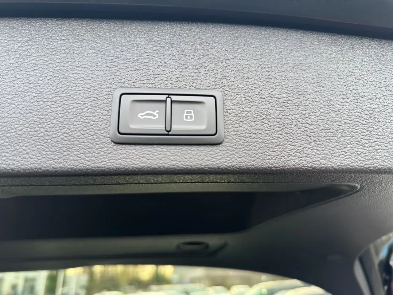 Boutons d'ouverture hayon motorisé et verrouillage sur le bord intérieur du hayon noir du Audi Q2 35 TFSI 2023.