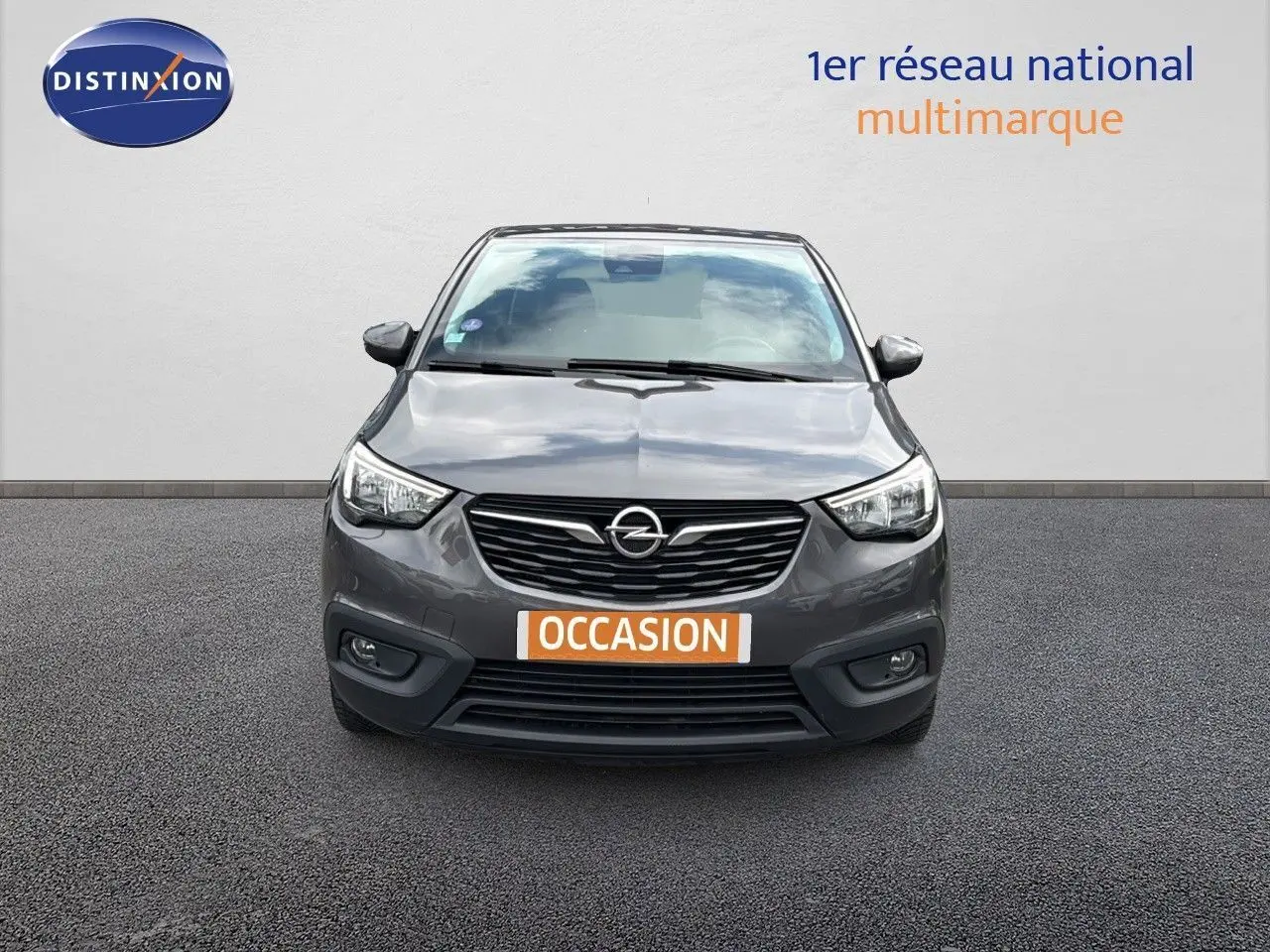 Vue avant d'une Opel Crossland X gris pierre de lune métal avec calandre noire et phares LED allumés.