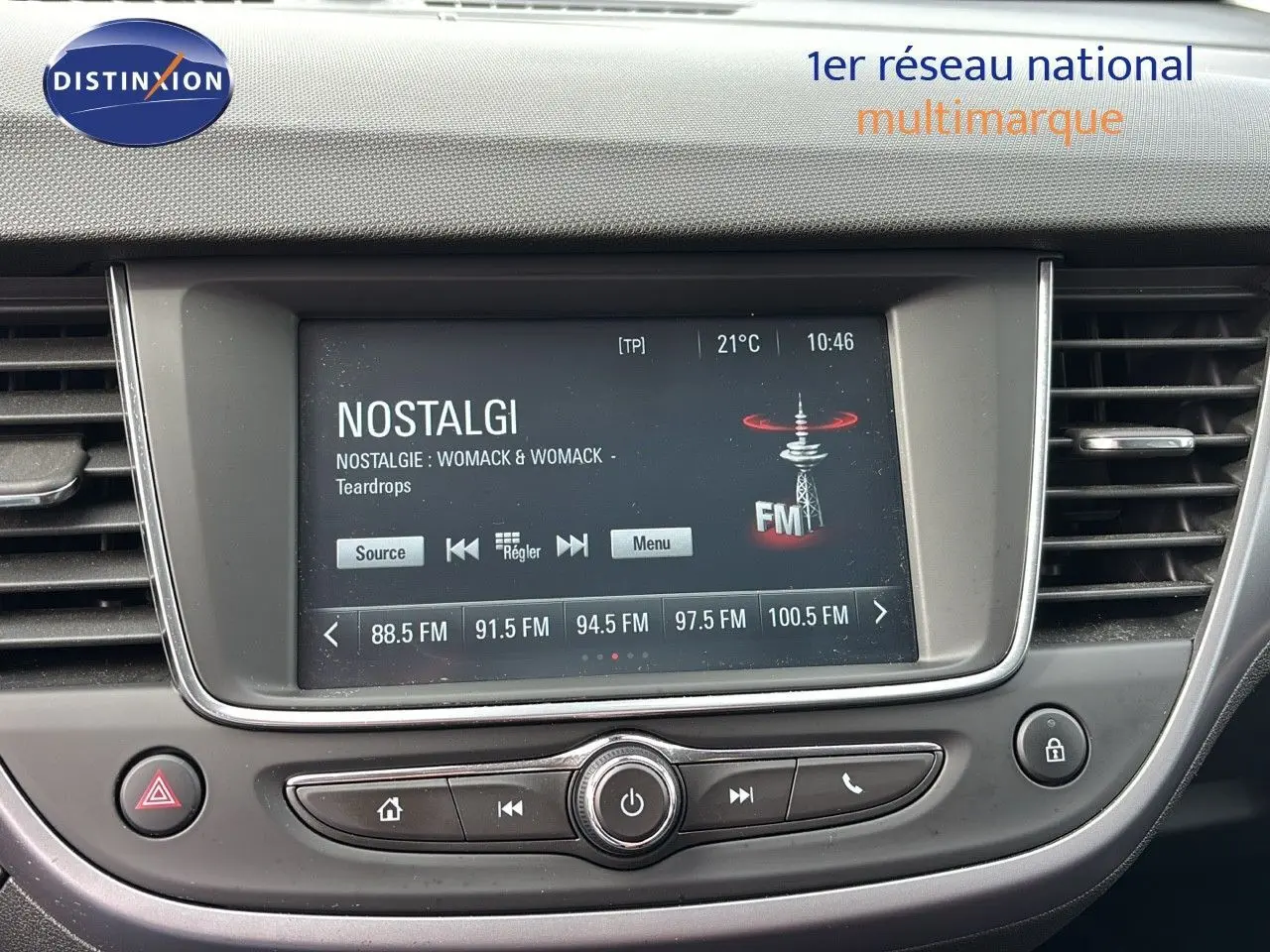Tableau de bord de l'Opel Crossland X 2020, écran central affichant une radio FM, entouré de commandes noires et grises.