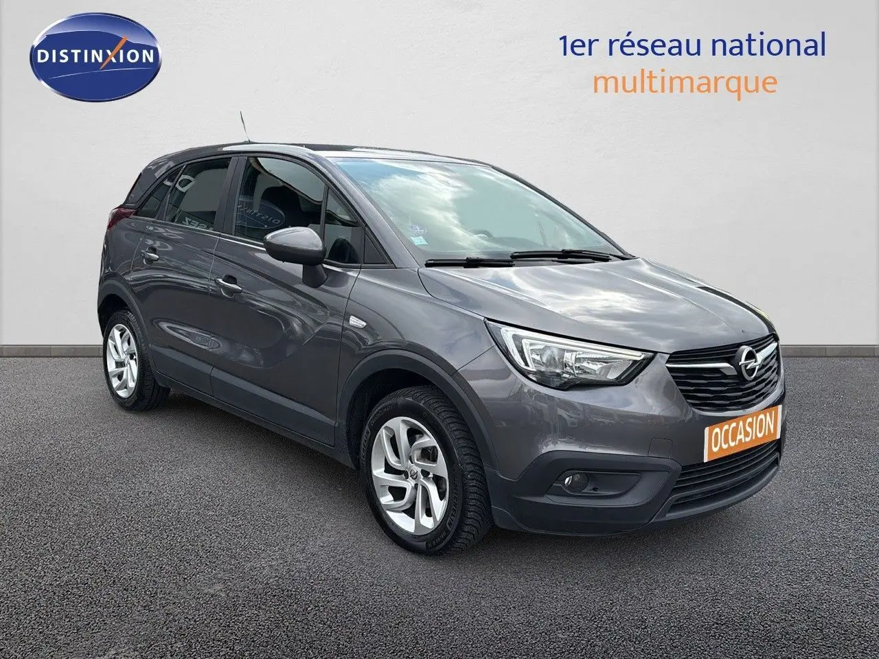 Opel Crossland X gris pierre de lune métal en 3/4 avant droit, avec jantes alliage et calandre noire distinctive.