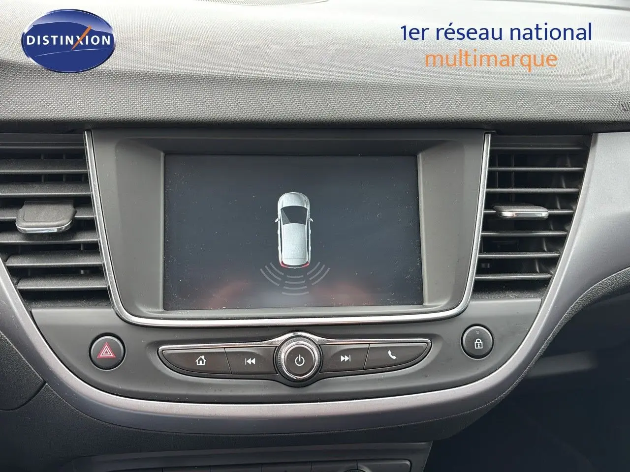 Vue rapprochée de l'écran central et des commandes du tableau de bord d'une Opel Crossland X gris pierre de lune métal.