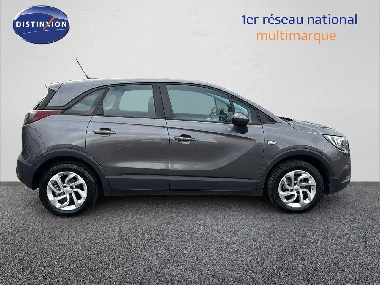 Profil côté gauche d'un Opel Crossland X gris Pierre de Lune métal, compact et moderne, sur fond neutre.
