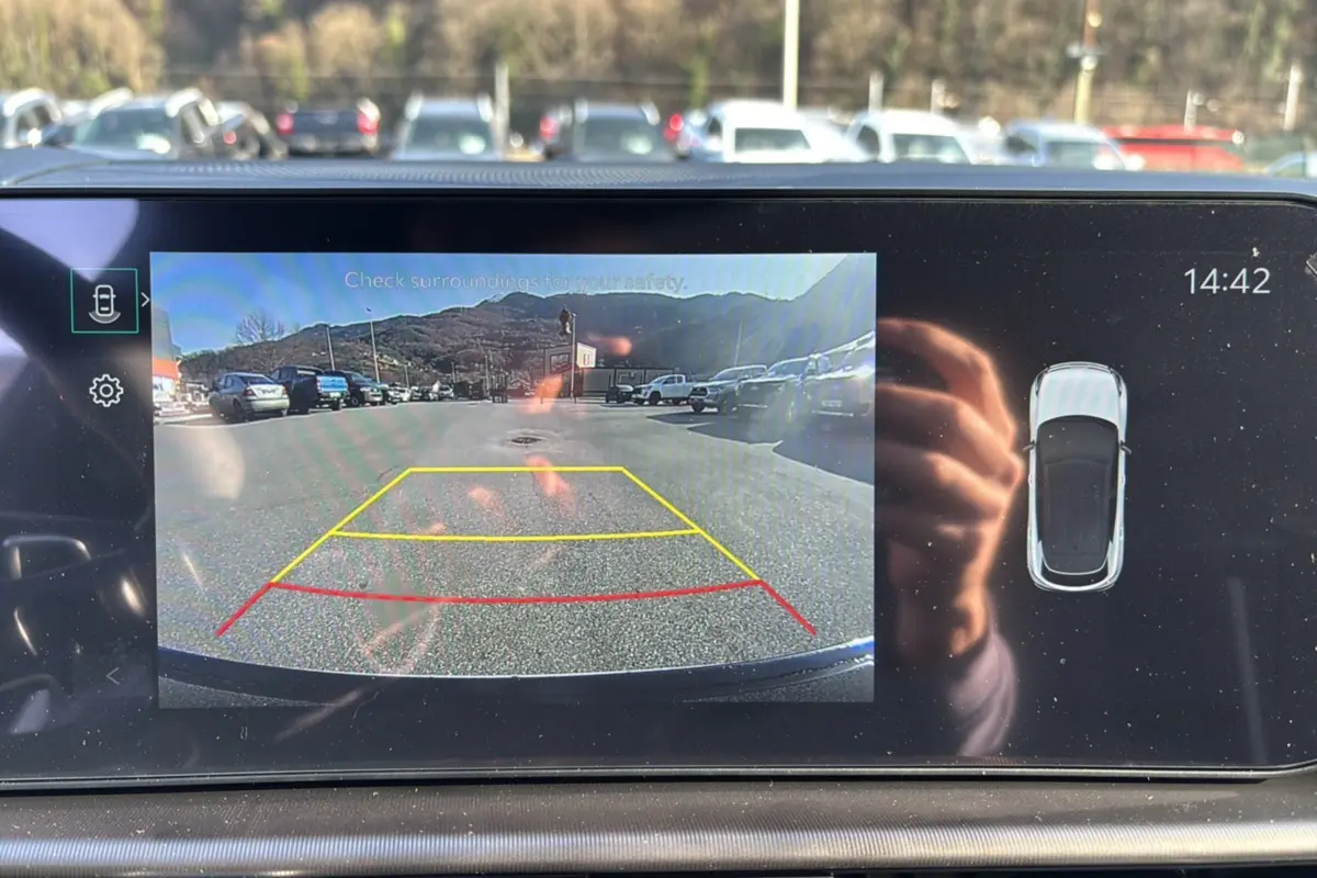 Écran intérieur affichant la caméra de recul et l'angle mort d'un Kia Sportage 2026 blanc nacré toit noir.