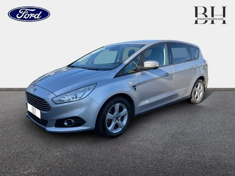 Ford S-MAX gris lunaire en vue 3/4 avant droit, avec calandre chromée et jantes alliage cinq branches.