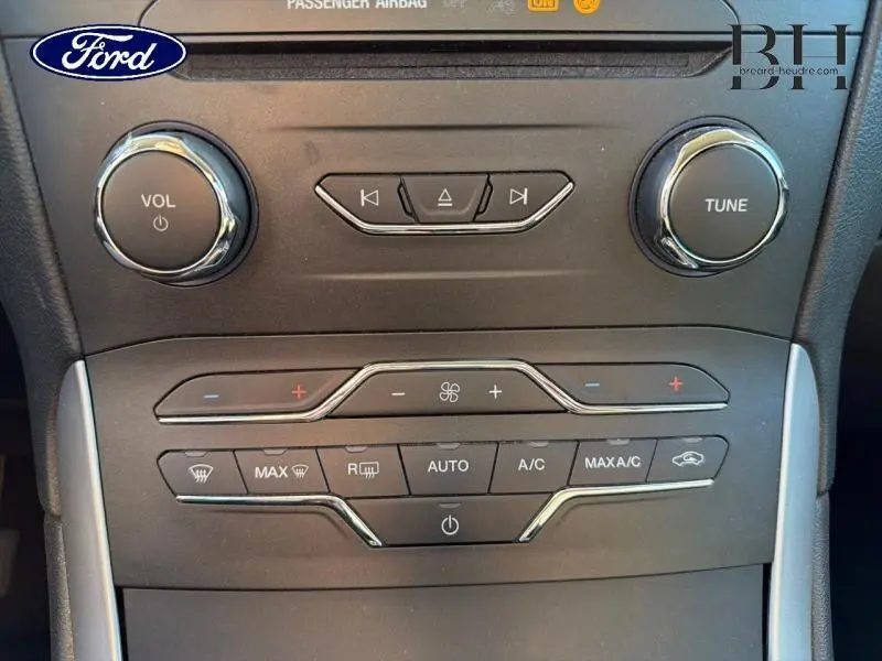 Vue rapprochée de la console centrale noire du Ford S-MAX 2016 avec commandes audio et climatisation.