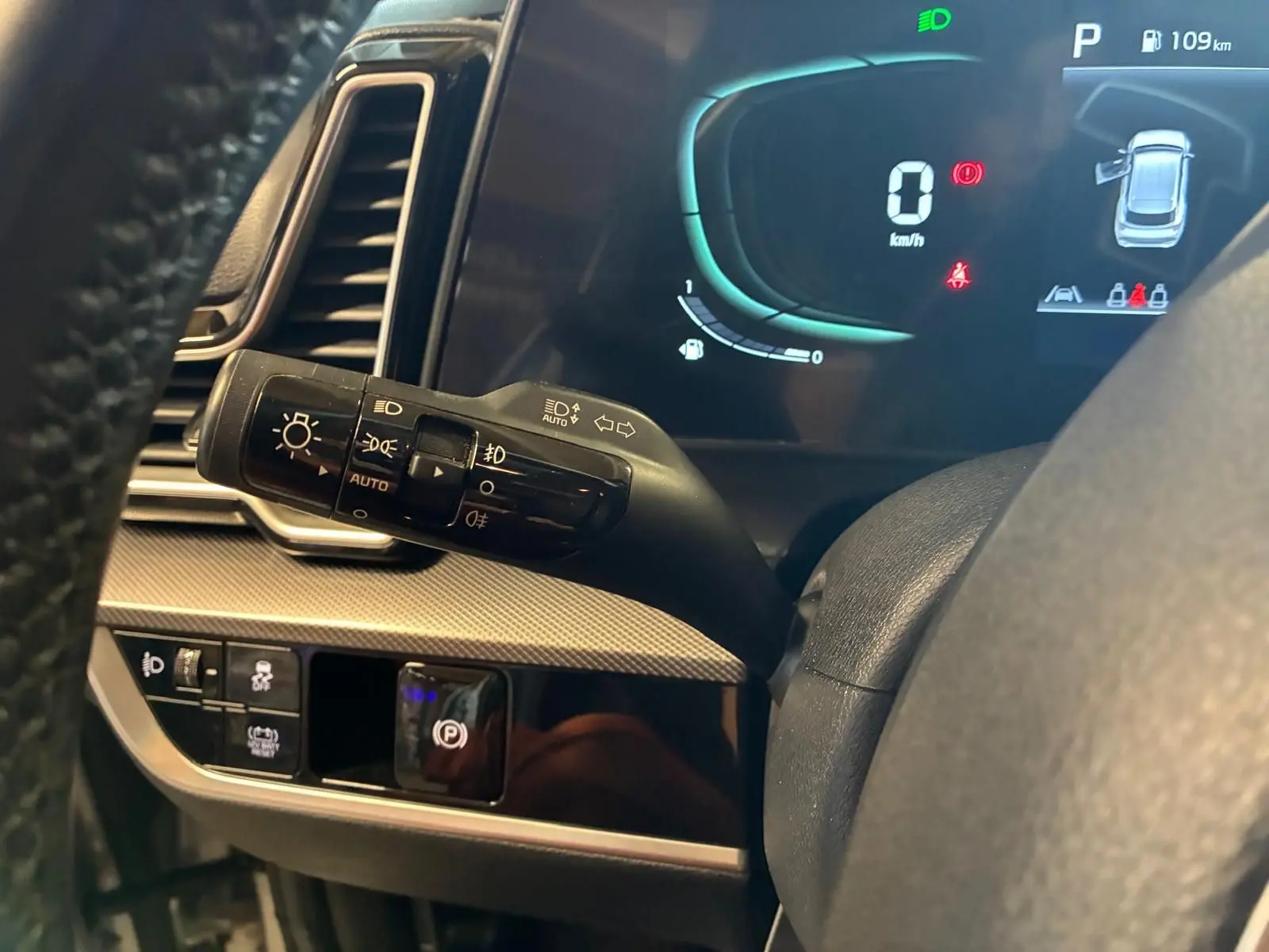 Détail intérieur du tableau de bord du KIA Sportage 2024 hybride, montrant le commodo d’éclairage et l’affichage numérique.