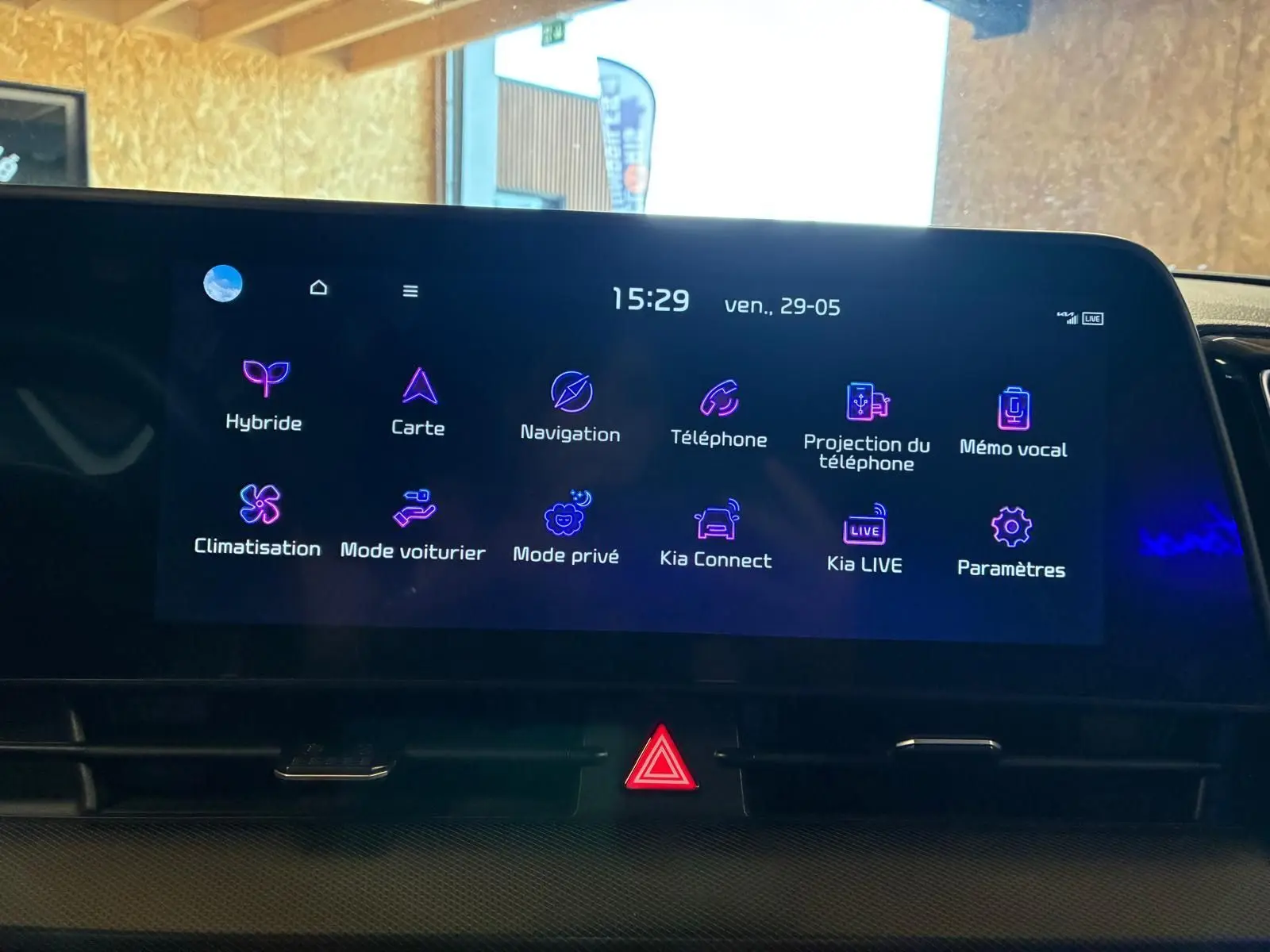 Écran tactile central du Kia Sportage hybride 2024 affichant les options de navigation et connectivité, vue de face en intérieur.