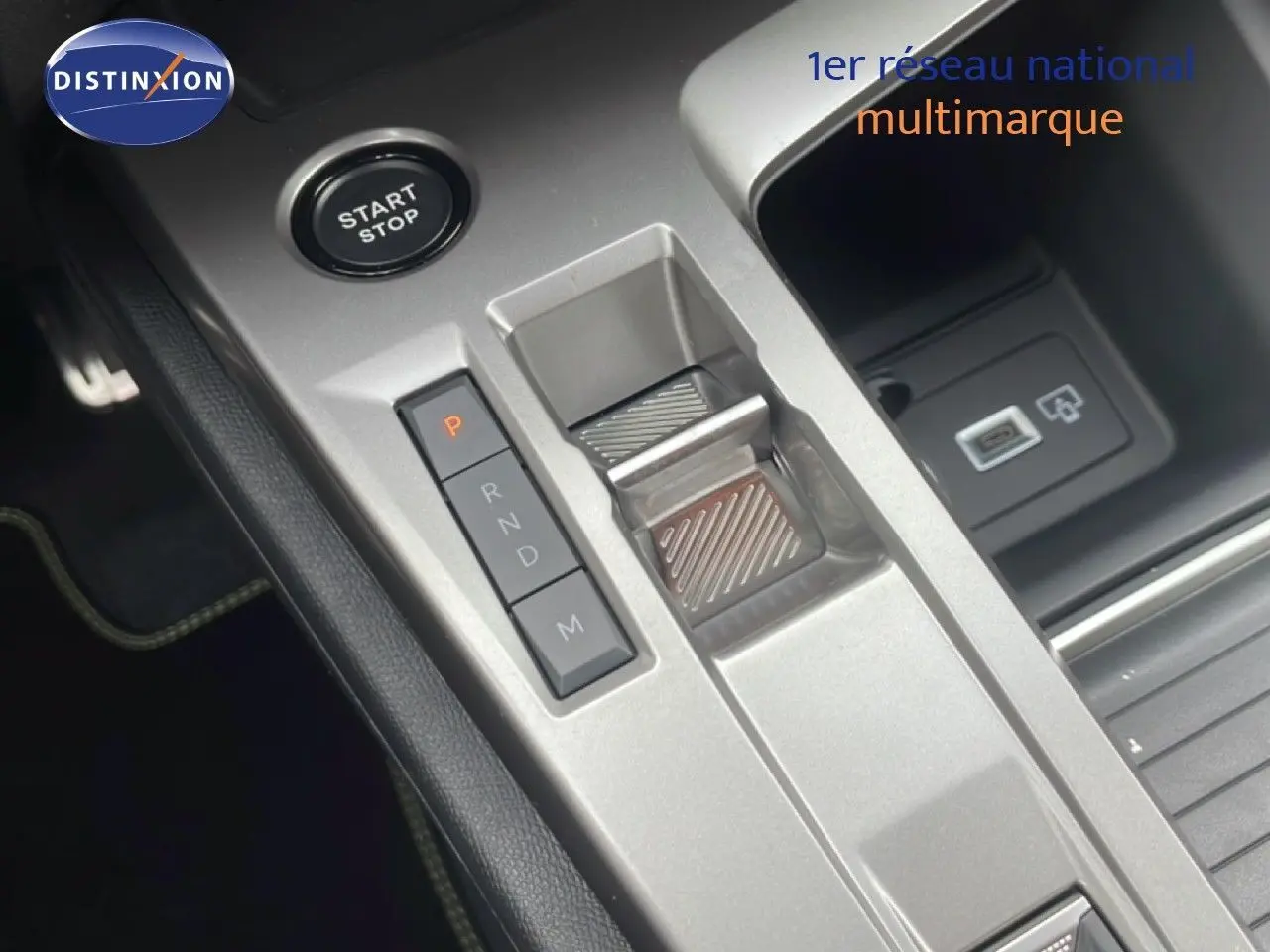 Vue rapprochée de la console centrale de la Peugeot 308 hybride 2026, avec bouton start/stop et levier de vitesses automatique.