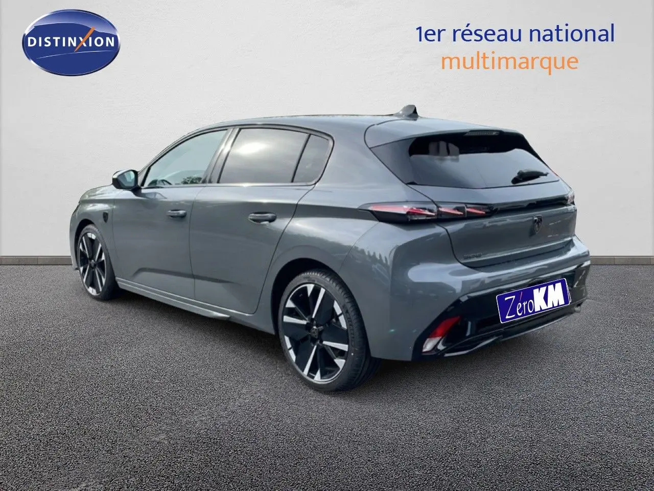 Vue 3/4 arrière droite d'une Peugeot 308 gris selenium métal avec jantes noires et feux arrière LED distinctifs.