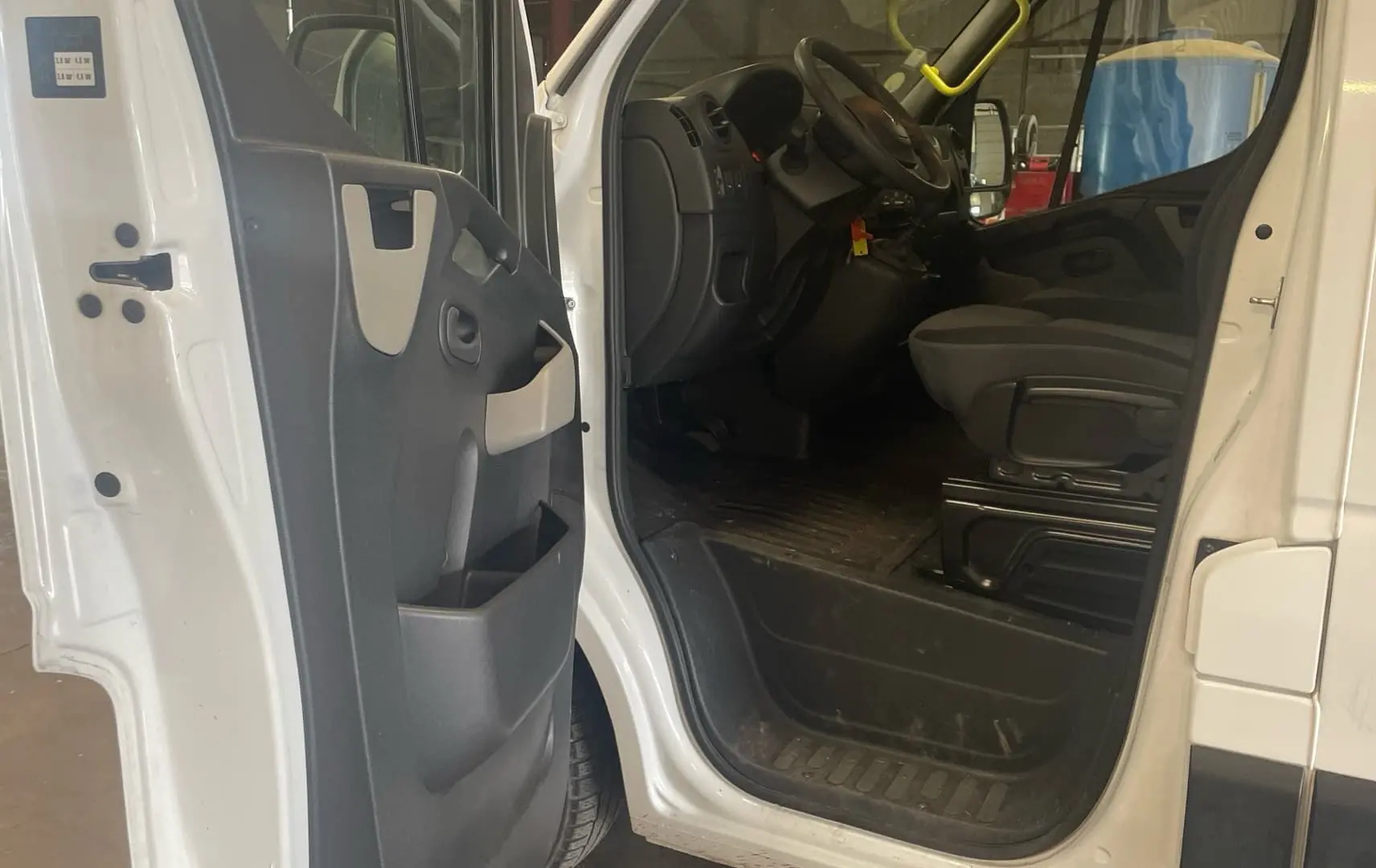 Vue intérieure côté conducteur du Renault Master blanc 2019 avec porte ouverte montrant le siège et le tableau de bord.