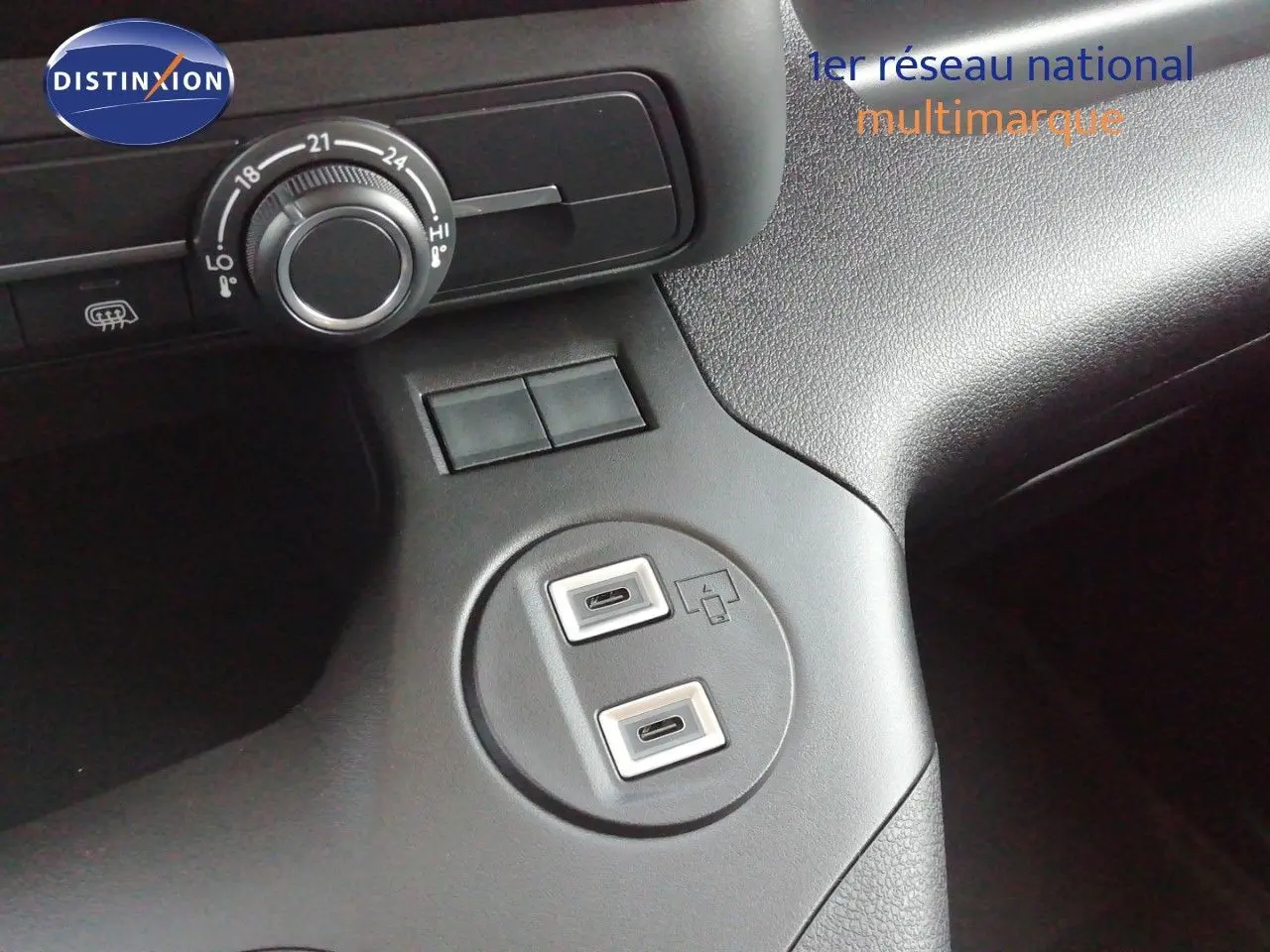 Vue rapprochée de la console centrale du Peugeot Partner blanc Kaolin 2026, avec prises USB et commandes de climatisation.