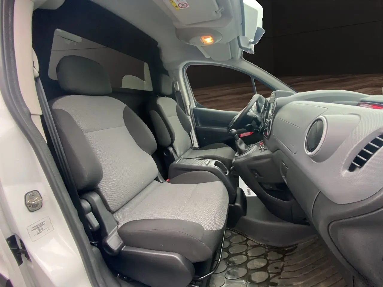 Vue intérieure côté conducteur du Citroën Berlingo blanc 2018, montrant les sièges avant et le tableau de bord.